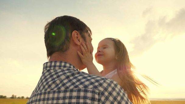 Isä halaa onnellista tytärtä kesäpuistossa. Isä ja pieni lapsi leikkivät yhdessä, nauravat ja halaavat. Onnellinen perhematka. terve vauva isän sylissä. Isä lähtee. Onnellinen perhe ja lapsuus - Valokuva, kuva