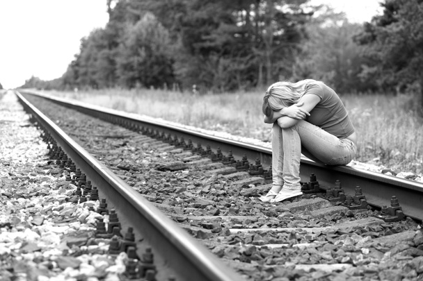 Verärgertes Mädchen sitzt auf den Schienen - Foto, Bild