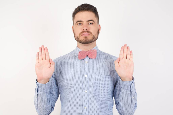 Vážný pohledný muž dělá gesto zastavit, ukazuje ruce zastavit  - Fotografie, Obrázek