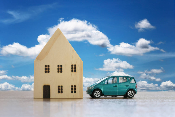 Drewniany dom i zabawki samochodów na koncepcji podłogi posiadania nieruchomości jako domu i samochodu. - Zdjęcie, obraz