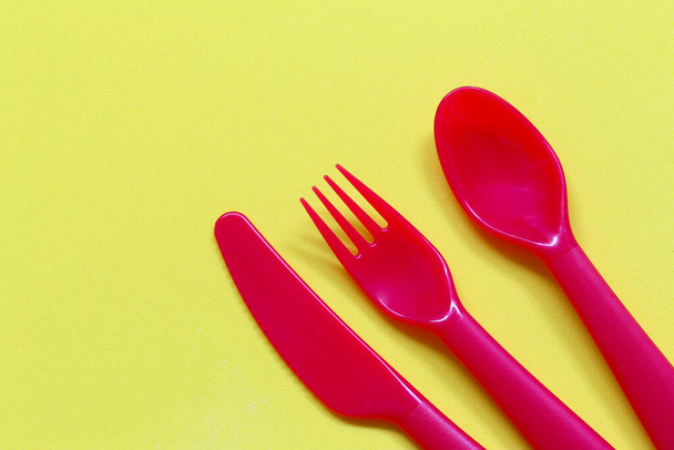 Cucchiaio rosso e forchetta su sfondo giallo e hanno spazio di copia per la progettazione nel vostro lavoro. - Foto, immagini