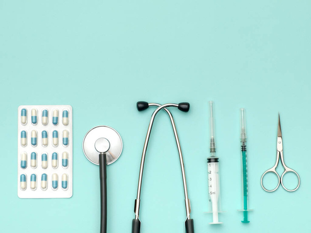 Top view of doctor's table with stethoscope and other equipment. Colored background. Top view. Flat lay - Фото, зображення