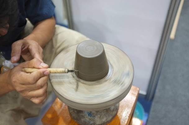 Concepto Taller de cerámica. El hombre arrojando un tazón de barro en una rueda de cerámica. - Foto, imagen