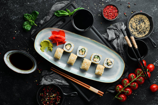 Rolls with cucumber, fish and cheese on a plate. Sushi. Top view. Rustic style. - Foto, immagini