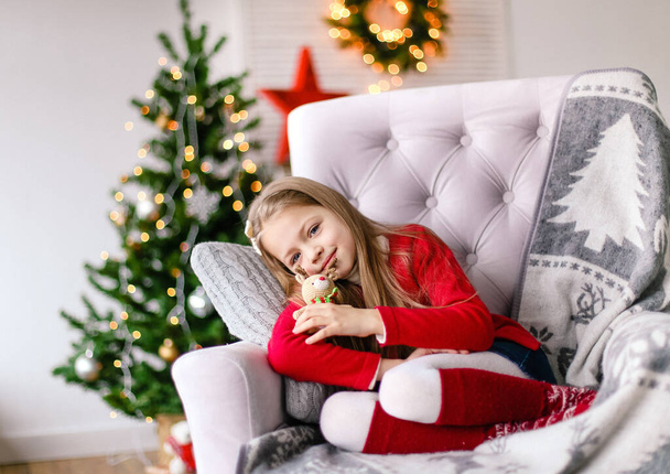 girl happy with a gift near the christmas tree christmas magic - Фото, изображение