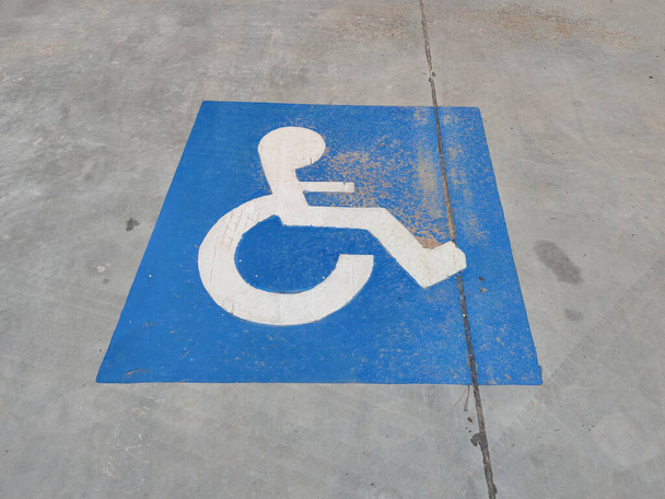 Kék tábla az aszfalton a mozgássérült parkolásról - Fotó, kép