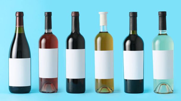 Weinflaschen mit leeren Etiketten auf farbigem Hintergrund. Mockup für Design - Foto, Bild