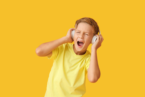 Little boy listening to music on color background - Photo, Image