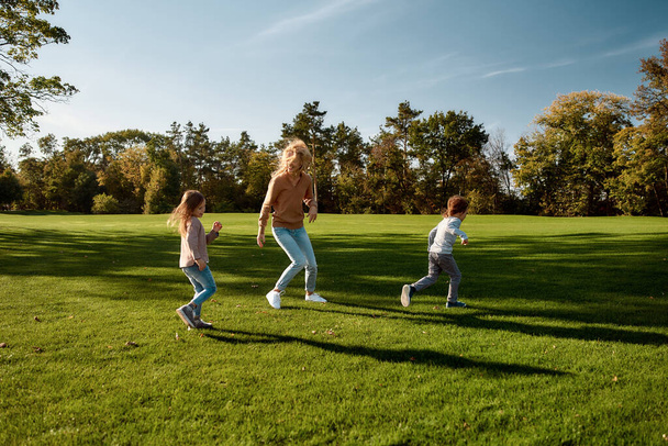 Providing happiness. Excited family running outdoors on a sunny day - Fotó, kép
