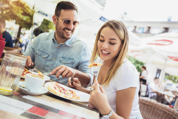 Photo of young couple enjoying in pizza, having fun together.  - Foto, afbeelding