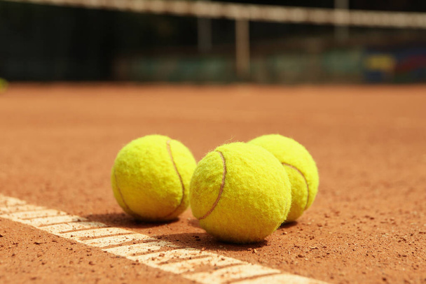 Light green tennis balls on clay court - Fotoğraf, Görsel