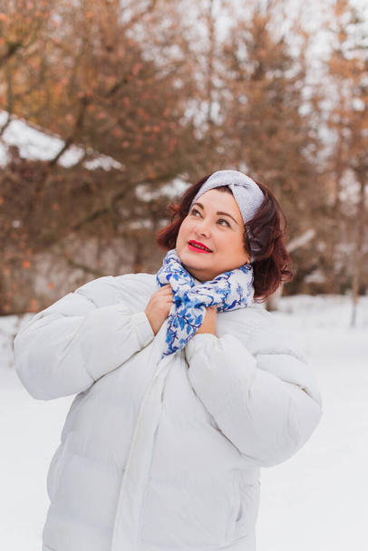 Christmas, winter holidays concept. Beautiful plus size woman walking . Love and peace for women, psychology and lifestyle of mature ladies - Photo, Image