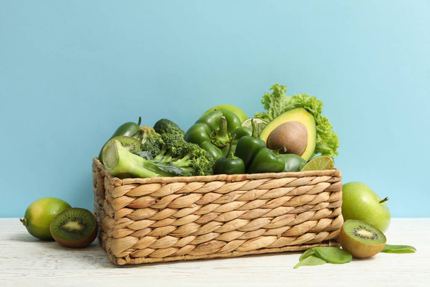 Basket with vegetable and fruits on blue background - Фото, изображение