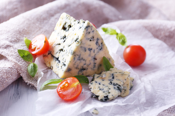 Tasty blue cheese with tomatoes and basil on paper - Фото, изображение
