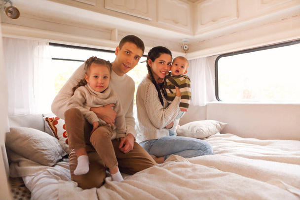 Portrait of the smiling happy family with kids in the house on wheels indoor - Foto, afbeelding