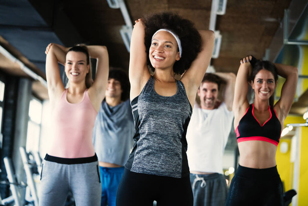 Group of happy fit people at the gym exercising - Foto, imagen