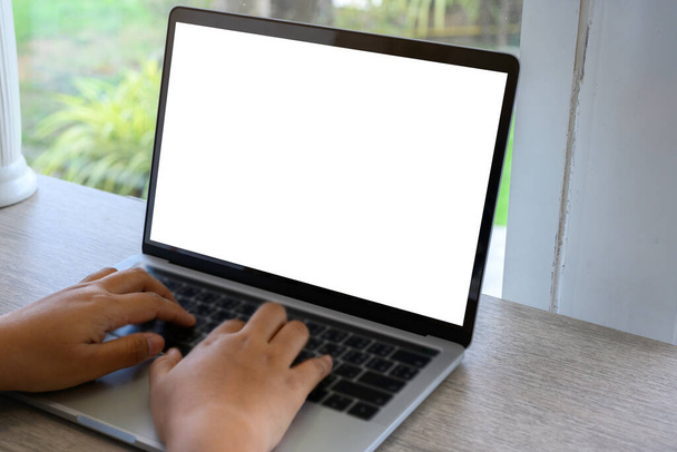 Üzletasszony kéz laptoppal mockup fehér háttér az asztalon kávézóban. üres képernyős számítógép. - Fotó, kép