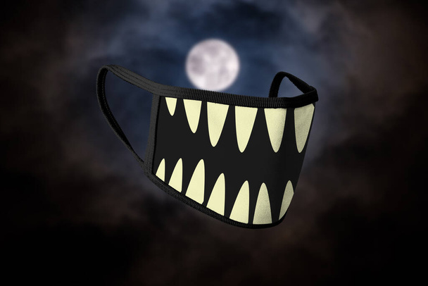 Maska na twarz o tematyce halloween z ostrymi zębami na brzegach. Pełnia księżyca tło. - Zdjęcie, obraz