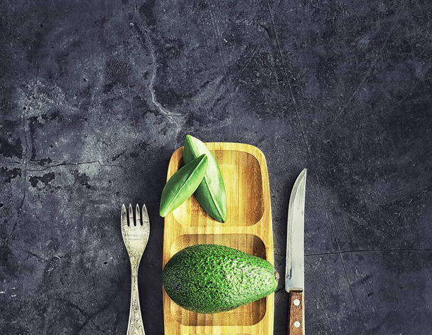 Przepisy gotowania awokado. Dojrzałe zielone awokado na desce do krojenia. - Zdjęcie, obraz