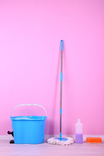 kat paspas ve kova için çamaşır odasında pembe duvar zemin üzerine - Fotoğraf, Görsel