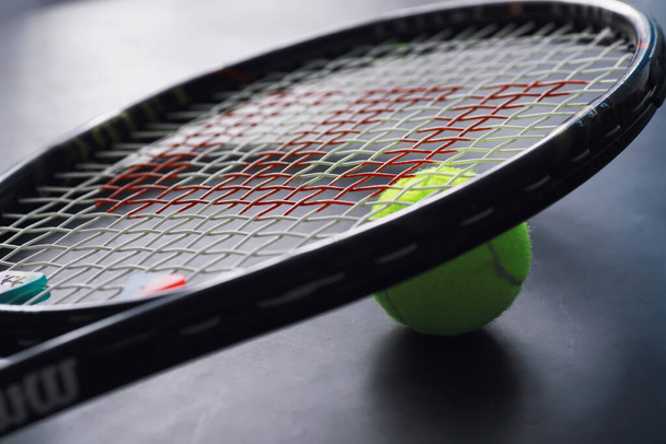 Sport en gezonde levensstijl. Tennis. Gele bal voor tennis en een racket op tafel. Sport achtergrond met tennis concept. - Foto, afbeelding
