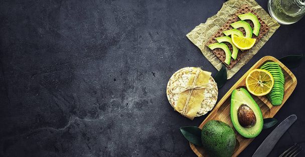 Avokado yemek tarifleri. Tahta kesme tahtasında servis edilen olgun yeşil avokado.. - Fotoğraf, Görsel