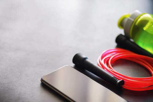 Jump rope. Physical education. Sports exercise equipment. Rope exercises routine. Pink jump rope stopwatch and water on the table. - Photo, Image
