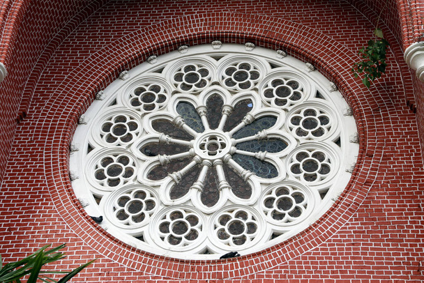 Padrão de flor de argamassa de círculo branco com vitrais e tijolo vermelho do exterior da igreja gable na catedral da trindade santa, a igreja da província de Mianmar. - Foto, Imagem