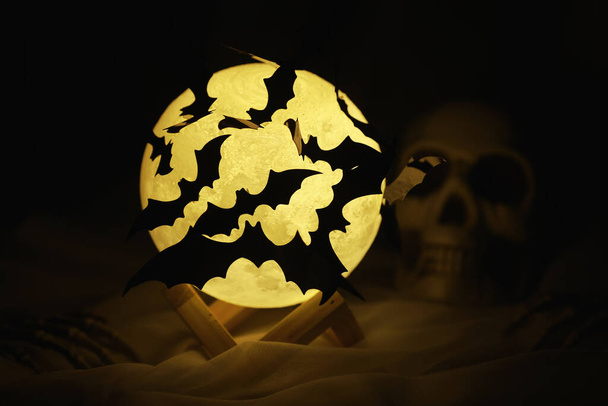 Zwarte silhouetten van vleermuizen op de achtergrond van de maan. Halloween concept. Enge achtergrond. Beangstigende abstracte objecten voor Halloween. - Foto, afbeelding