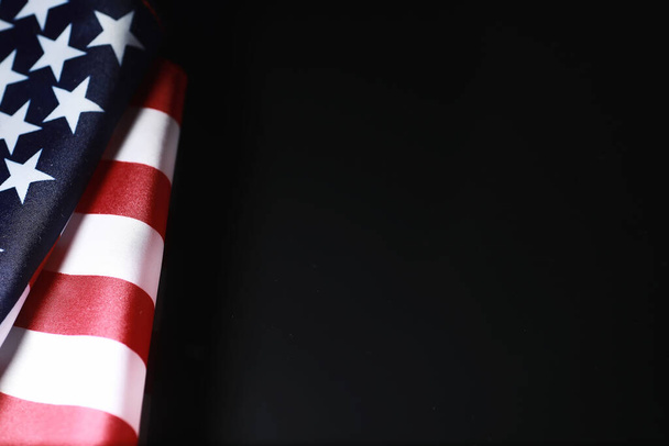 Amerikaanse vlag op een spiegelachtergrond. Symbool van de Verenigde Staten van Amerika. Sterrengestreepte vlag op zwarte achtergrond. - Foto, afbeelding