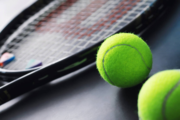 Sport und gesunder Lebensstil. Tennis. Gelber Tennisball und Schläger auf dem Tisch. Sportlicher Hintergrund mit Tenniskonzept. - Foto, Bild