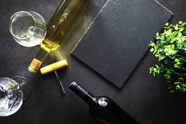 Sklenici červeného suchého vína na stole. Tmavá láhev a sklenice vína. - Fotografie, Obrázek