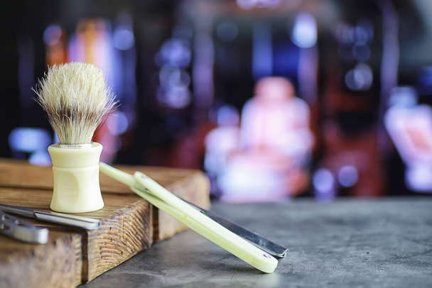 Shaving accessories on a wooden texture background. Tools. Disposable shaving machine, brush, foam hazard razor. - Fotó, kép