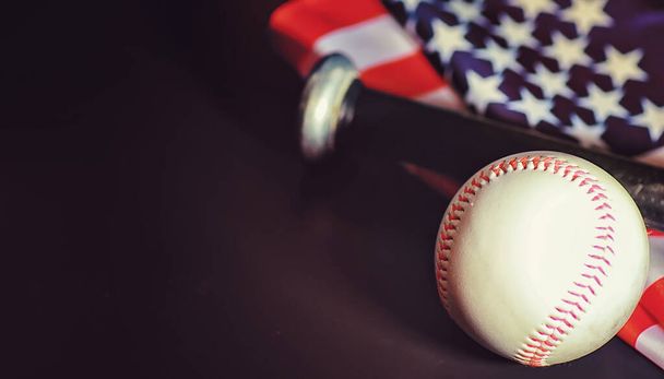 Amerikkalainen perinteinen urheilupeli. Baseballia. Konsepti. Baseball pallo ja lepakot pöydällä Amerikan lippu. - Valokuva, kuva