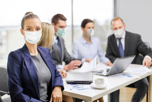 businesswoman in mask with colleagues at office - Foto, immagini