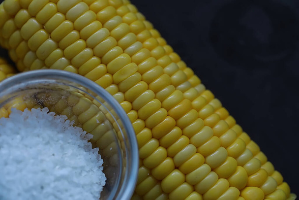 Свежеиспечённое благоухающее ухо кукурузы с солью. Свежая кукуруза. Здоровый завтрак и концепция здорового образа жизни. - Фото, изображение