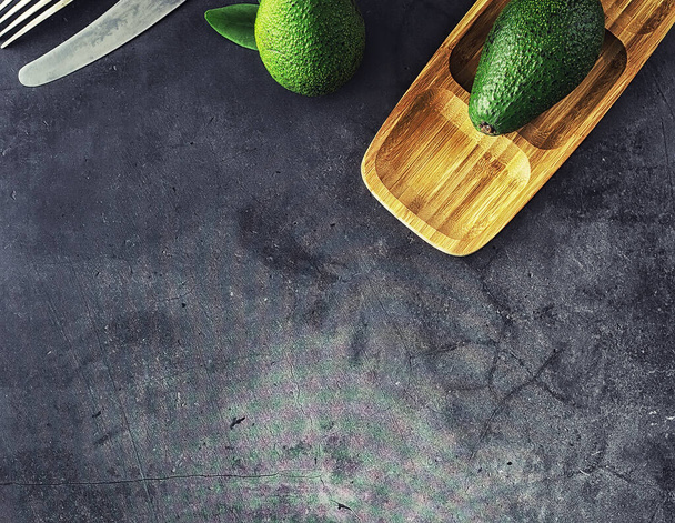 Рецепты приготовления авокадо. Спелые зеленые авокадо на деревянной разделочной доске. - Фото, изображение