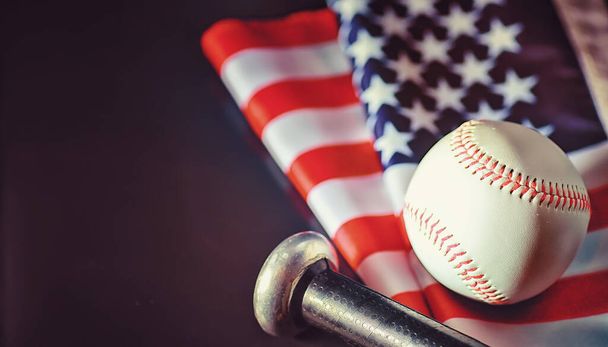 American traditional sports game. Baseball. Concept. Baseball ball and bats on table with american flag. - Foto, Bild