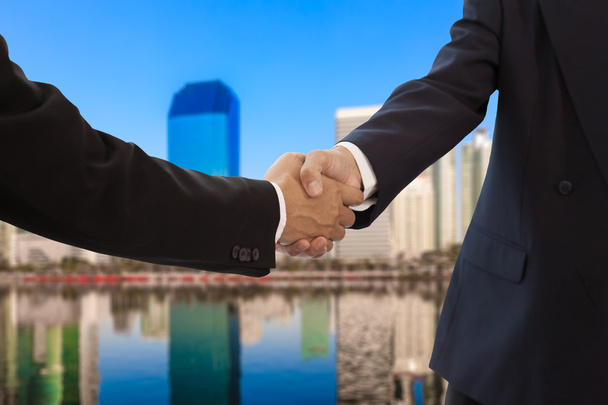 Businessman handshake with building background - Photo, Image