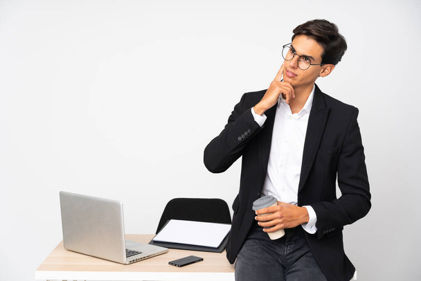 Businessman in his office over isolated white background thinking an idea - Foto, afbeelding