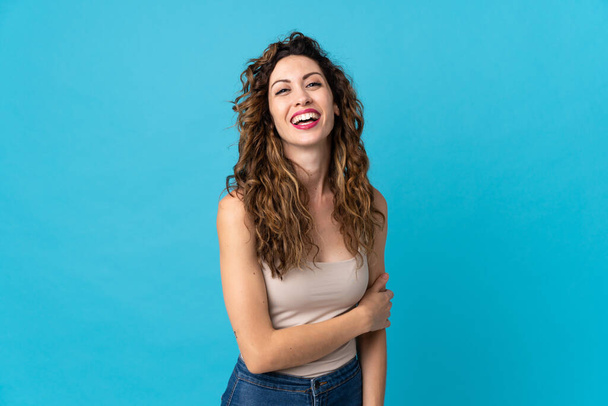 Young caucasian woman isolated on blue background laughing - Foto, imagen