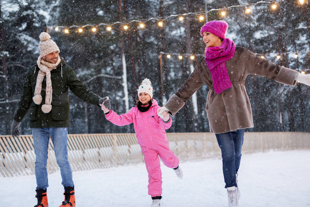 happy family at outdoor skating rink in winter - Foto, afbeelding