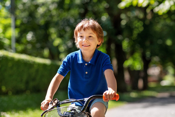 happy little boy riding bicycle at summer park - Foto, Bild