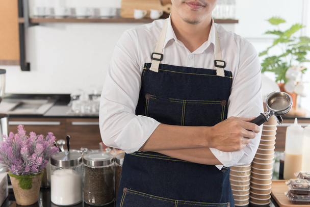 Close up of barista man standing cross-hand and holding a coffee tampe - Φωτογραφία, εικόνα