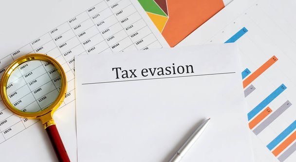 Уклонение от уплаты налогов написано на бумажных таблицах - Фото, изображение