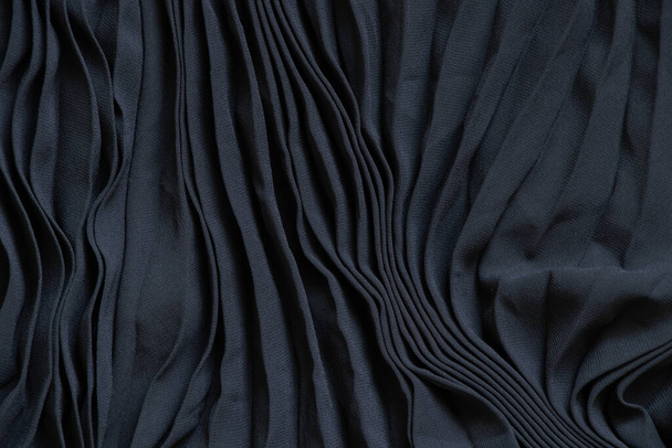 tela lisa y negra plisada con líneas como fondo, la tela está planchada con rayas - Foto, imagen