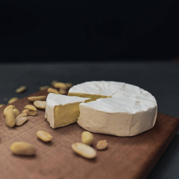 kaas camembert met schimmel en noten op houten plank - Foto, afbeelding