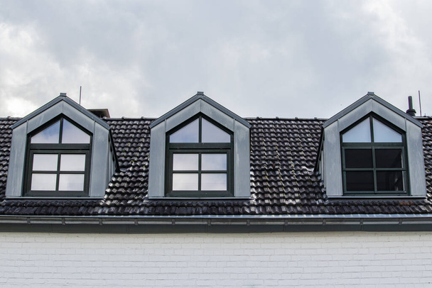 A closeup shot of a black roof with three windows - Foto, Bild
