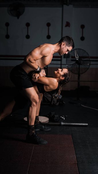 A vertical shot of an athletic male and female in the gym - Foto, afbeelding