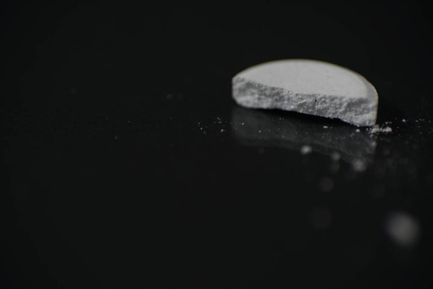 A closeup shot of a half-broken pill - Fotó, kép